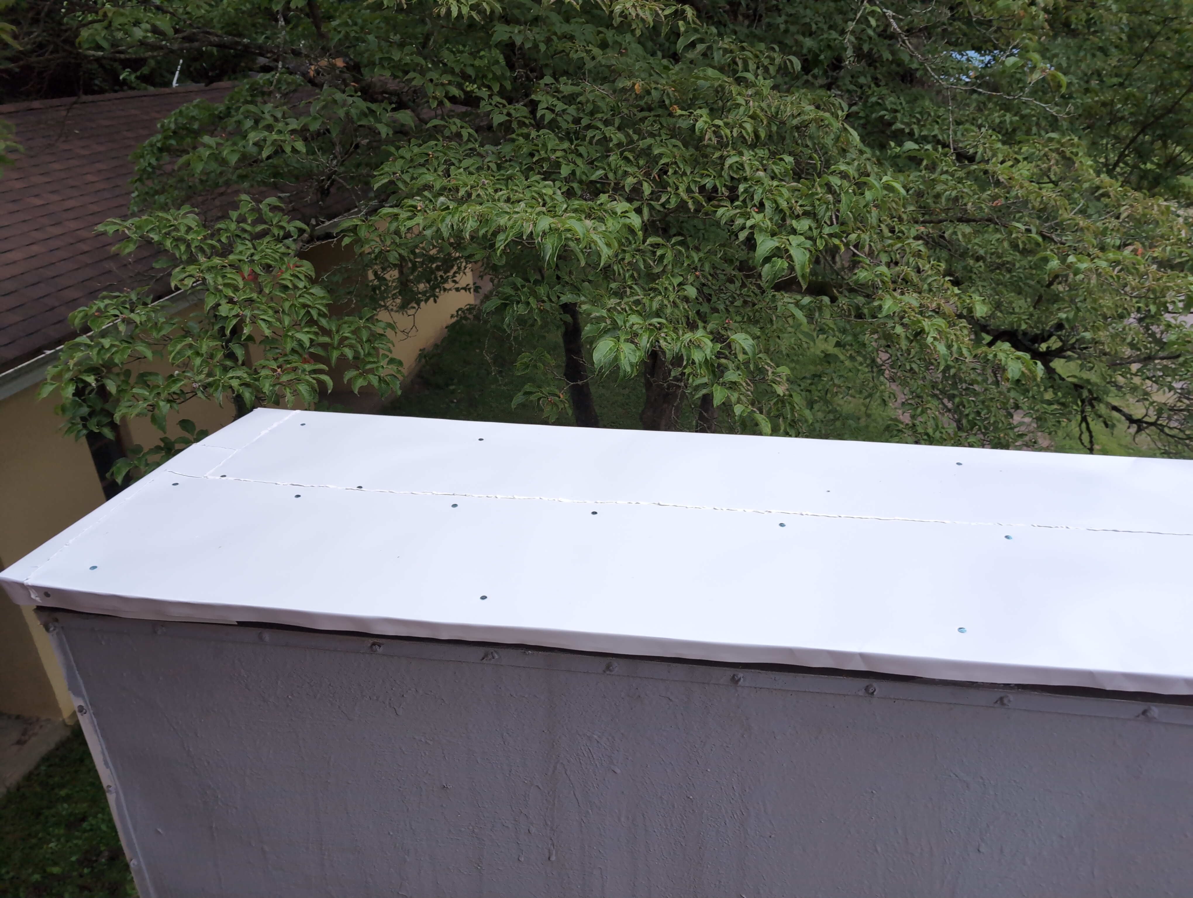 The roof is now covered in a white metal sheeting, with visible silver nail heads, and raised white lines on the seams that could be mistaken for sloppy welding under paint, but was actually that sealant.